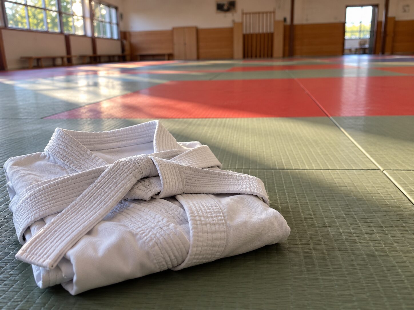 Karategi plié sur un tatami dans un dojo vide